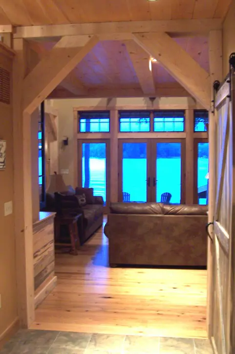 A living room with wood floors and windows.