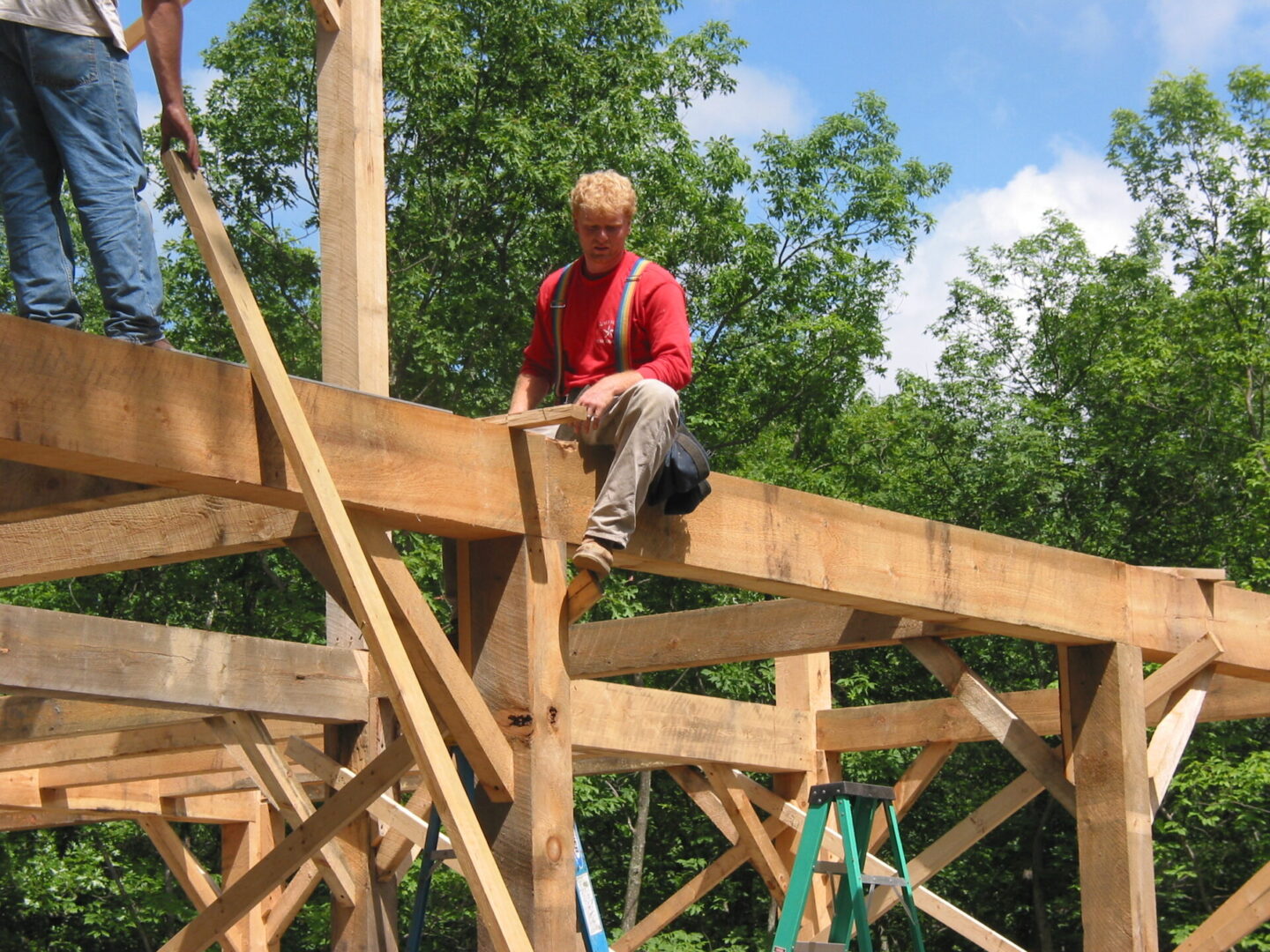 A man sitting on top of a wooden structure.