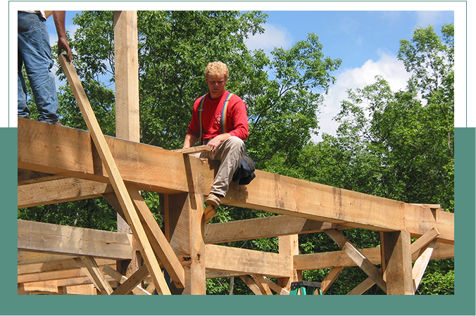 A man sitting on top of wooden structure.